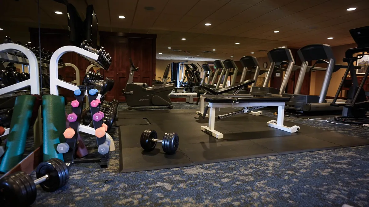 A well-equipped fitness center with dumbbells, exercise machines, and weight benches. The space is bright and motivational, designed to support a healthy routine even while away from home.